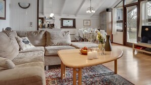 A spacious living area with a high ceiling, a sofa, a coffee table, and a dining area with chairs and a table. - "Hildegarda" - 1km from the sea by Interhome (Sæby)