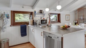 A modern kitchen with white cabinetry, a built-in dishwasher, and pendant lighting. - "Hildegarda" - 1km from the sea by Interhome (Sæby)