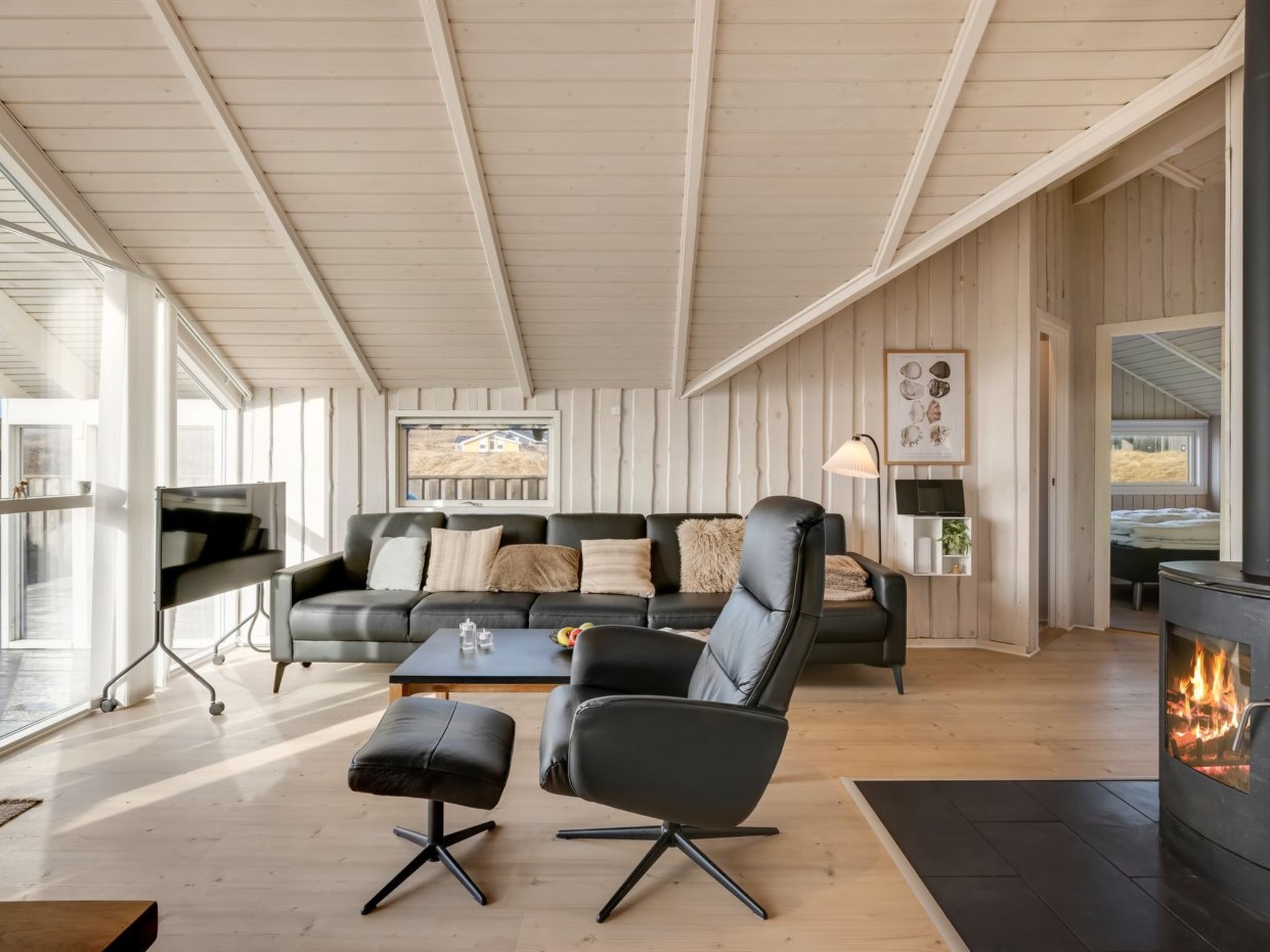 Een moderne woonkamer met een open haard, een bank, een salontafel en een televisie.