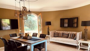 A living room with a dining table, chairs, a sofa, and a TV. - Fantastically beautiful ambience on 93sqm in Peschiera, 5 min=lake 7min=center, balcony (Peschiera del Garda)