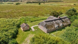 A rural house with a thatched roof, surrounded by a grassy field and trees. - "Vangja" - 700m to the fjord by Interhome (Hvide Sande)