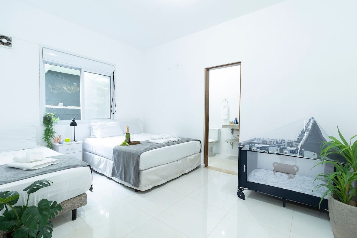 Ein modernes Schlafzimmer mit Bett, Nachttisch und einer Glasvitrine mit Bär-Motiv.