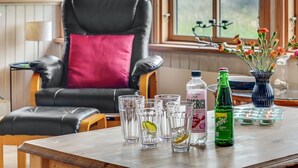 A room with a leather chair, a table with glasses and bottles, and a window with a view. - "Marite" - 200m from the sea by Interhome (Pandrup)