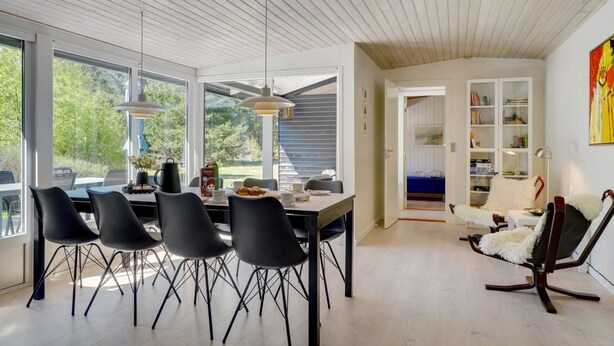A modern interior with a dining area, a reading nook, and a bedroom. - "Orvokki" - 125m from the sea by Interhome (Sæby)