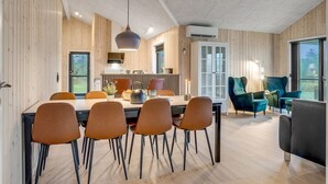 Un interior moderno con comedor, cocina y zona de estar.