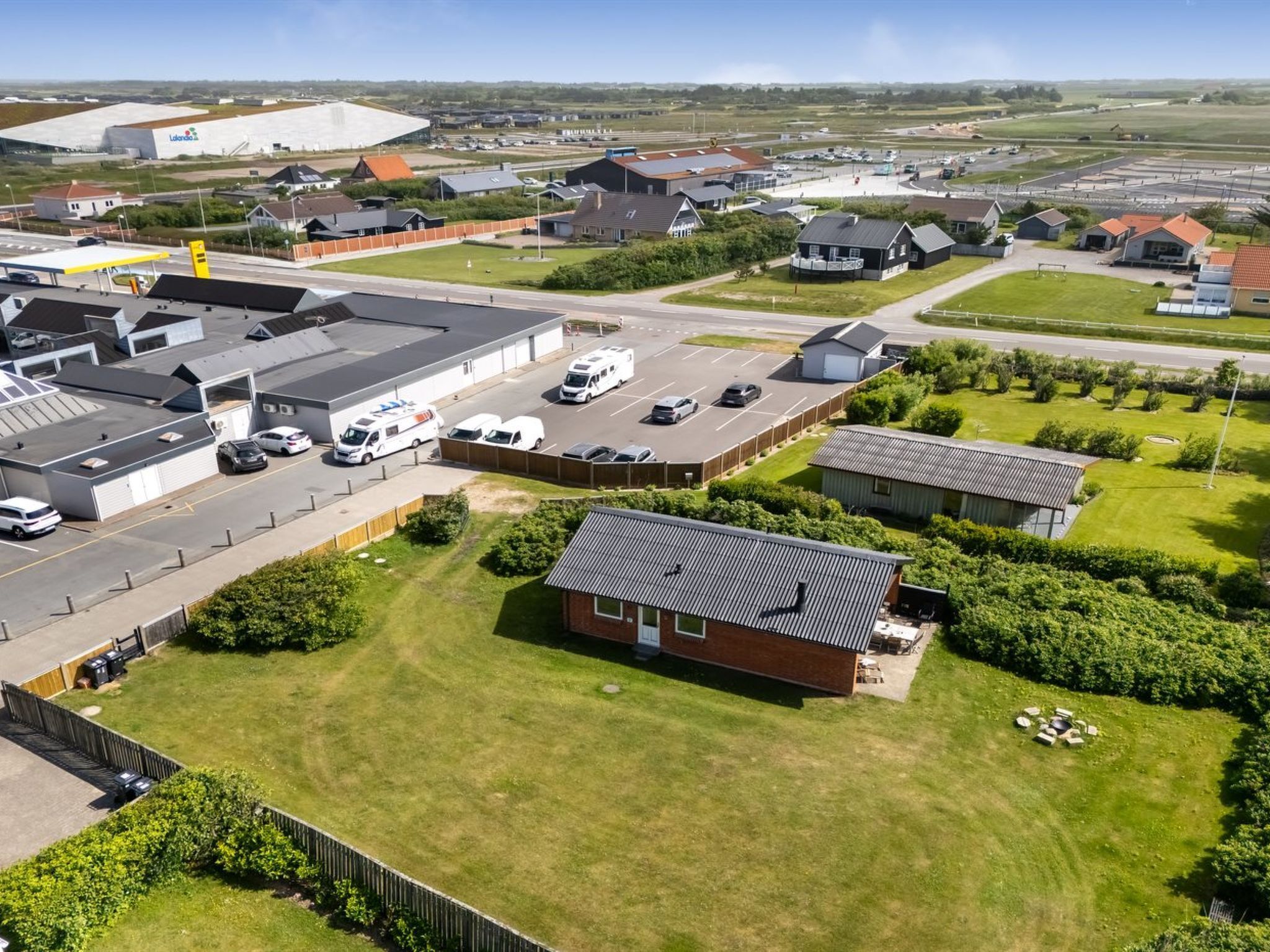 Ett industriområde med lagerlokaler, en parkeringsplats och en liten byggnad med ett sluttande tak.