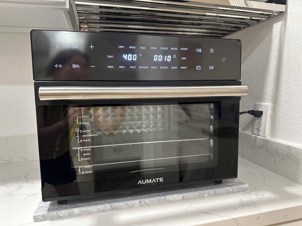 Una cocina moderna con horno empotrado, que muestra controles digitales de temperatura y opciones de cocción.