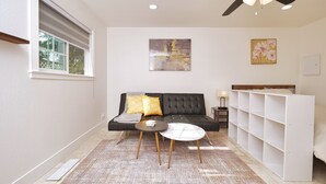 Una sala de estar moderna con un sofá, una mesa de centro y un ventilador de techo.