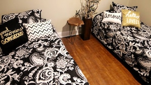 Une chambre à coucher avec deux lits, chacun agrémenté de draps à motifs et de coussins décoratifs.