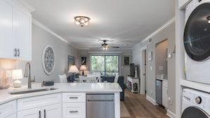 A modern kitchen with white cabinets, a dishwasher, and a ceiling fan. - Short easy walk to BEACH. 
Pools, tennis & pickleball. Cozy & Shore 2 Please! (Hilton Head Island)
