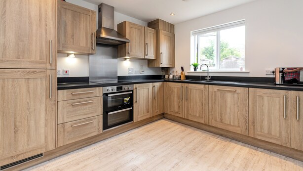 A modern kitchen with wooden cabinets, a black countertop, stainless steel appliances, and a window providing natural light. - 5 Bed House - Sleeps 9 - Pets - Garden - Parking (Ashford)