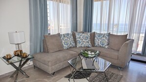 Ein Wohnzimmer mit einer Couch, einem Glastisch und einer Lampe.