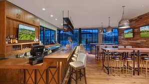 A modern bar area with wooden cabinets, a long counter, and bar stools. - The Troubadour at Tapatio Springs- Golf, Swimming Pool, Restaurant & Bar. (Boerne)