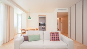 A modern living room with a sofa, a dining table, and a kitchen area. - Allegro Boutique Apartment A (Porto)