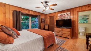 A bedroom with a bed, a television, a dresser, and a window with a view of greenery. - Private pet-friendly escape w/ Views, Fenced Yard, Stocked kitchen, Fireplace (Maggie Valley)