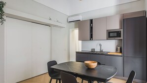 A modern kitchen with a black marble table, dark cabinets, and a wooden bowl. - Palazzo Bozzanca by Wonderful Italy (Syracuse)