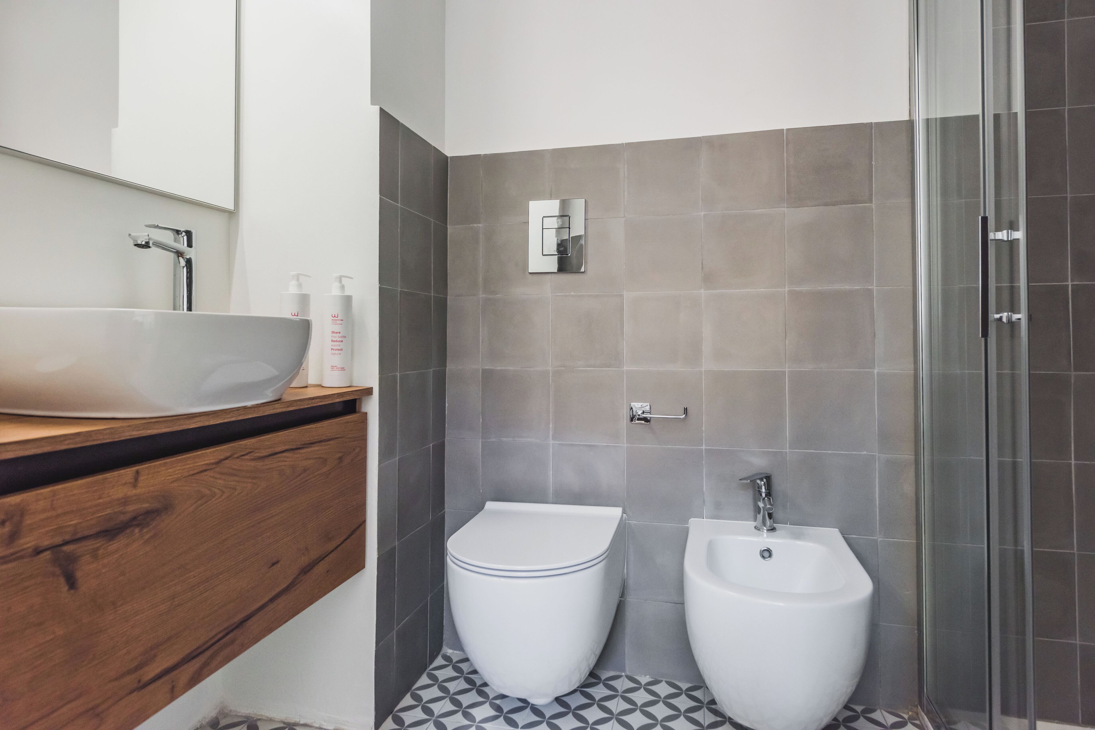 Un bagno moderno con un lavabo sospeso, un water e un bidet.