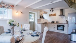A modern kitchen with white cabinetry, a built-in oven, and a stainless steel refrigerator. - The Stables - 2 Bedroom Cottage - Princes Gate (Narberth)