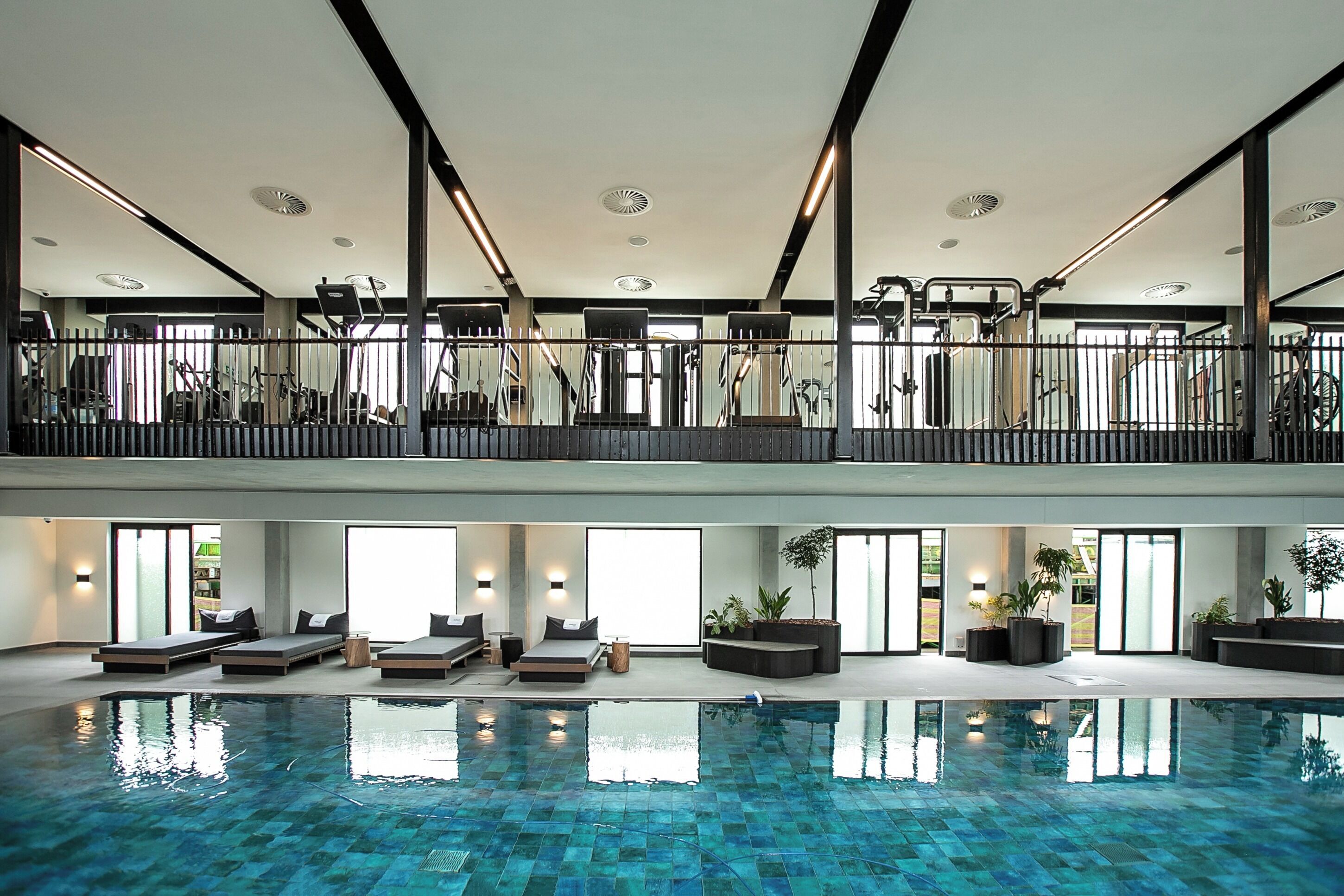 Una piscina interna su più livelli con zone illuminate dal sole e attrezzature per esercizi.