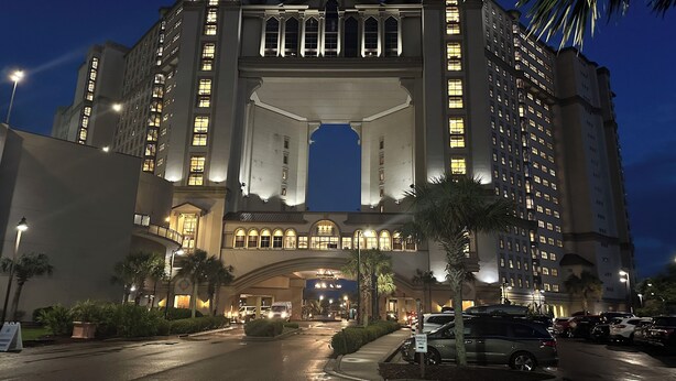 A large, multi-story hotel with a grand entrance and multiple illuminated windows. - Luxury 3 Bedroom Villa @ N. Beach Resort - Walk to Everything! Beach/Pools/Food (North Myrtle Beach)