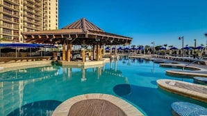 A hotel pool area with a gazebo, multiple swimming pools, and a tall building in the background. - Luxury 3 Bedroom Villa @ N. Beach Resort - Walk to Everything! Beach/Pools/Food (North Myrtle Beach)