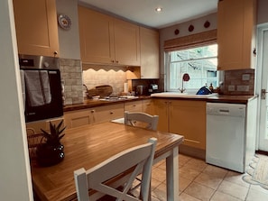 Compact kitchen with modern appliances, Bosch dishwasher, microwave, and stove, perfect for meal preparation.