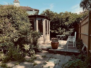 Relax in a serene backyard oasis with a charming gazebo, lush greenery, and a peaceful seating area.