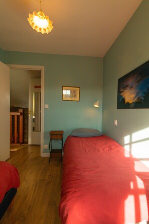 Une chambre à coucher avec un lit, une table de chevet, une lampe et un tableau au mur.
