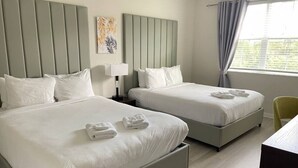A hotel room with two beds, a desk, and a chair. - Modern 3B2b APT near Convention Center Universal 7 (Orlando)