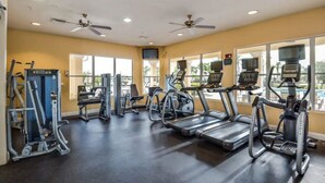 Un gimnasio con cintas de correr, elípticas y máquinas de pesas.