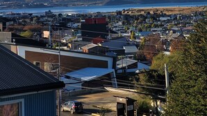 A town with buildings and a mountain range in the background. - Hostería Bella Ushuaia (Ushuaia)