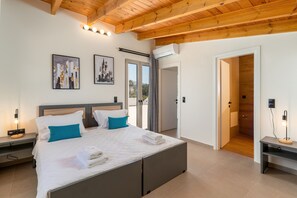 Relax in a serene bedroom with a large bed, two accent pillows, and framed artworks on the wall.
