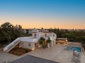 Enjoy an outdoor space with a pool and covered patio, surrounded by lush greenery.