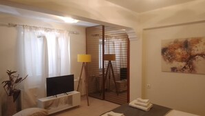 Une chambre d’hôtel avec un lit, une télévision, une lampe et un tableau au mur.
