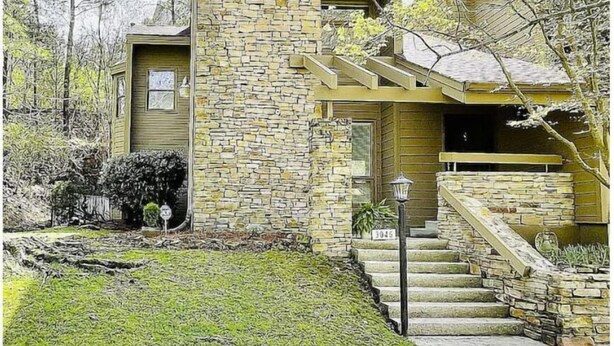 A stone house with a small porch and a staircase leading to the entrance. - Townhouse by the River (Birmingham)