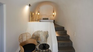Una escalera con una pared blanca y un banco de madera.