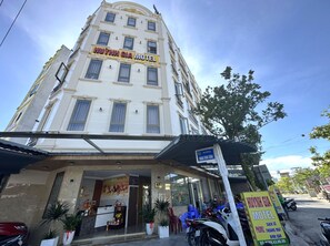 Un immeuble à plusieurs étages avec une enseigne indiquant « HUYNH GI A MOTEL ».