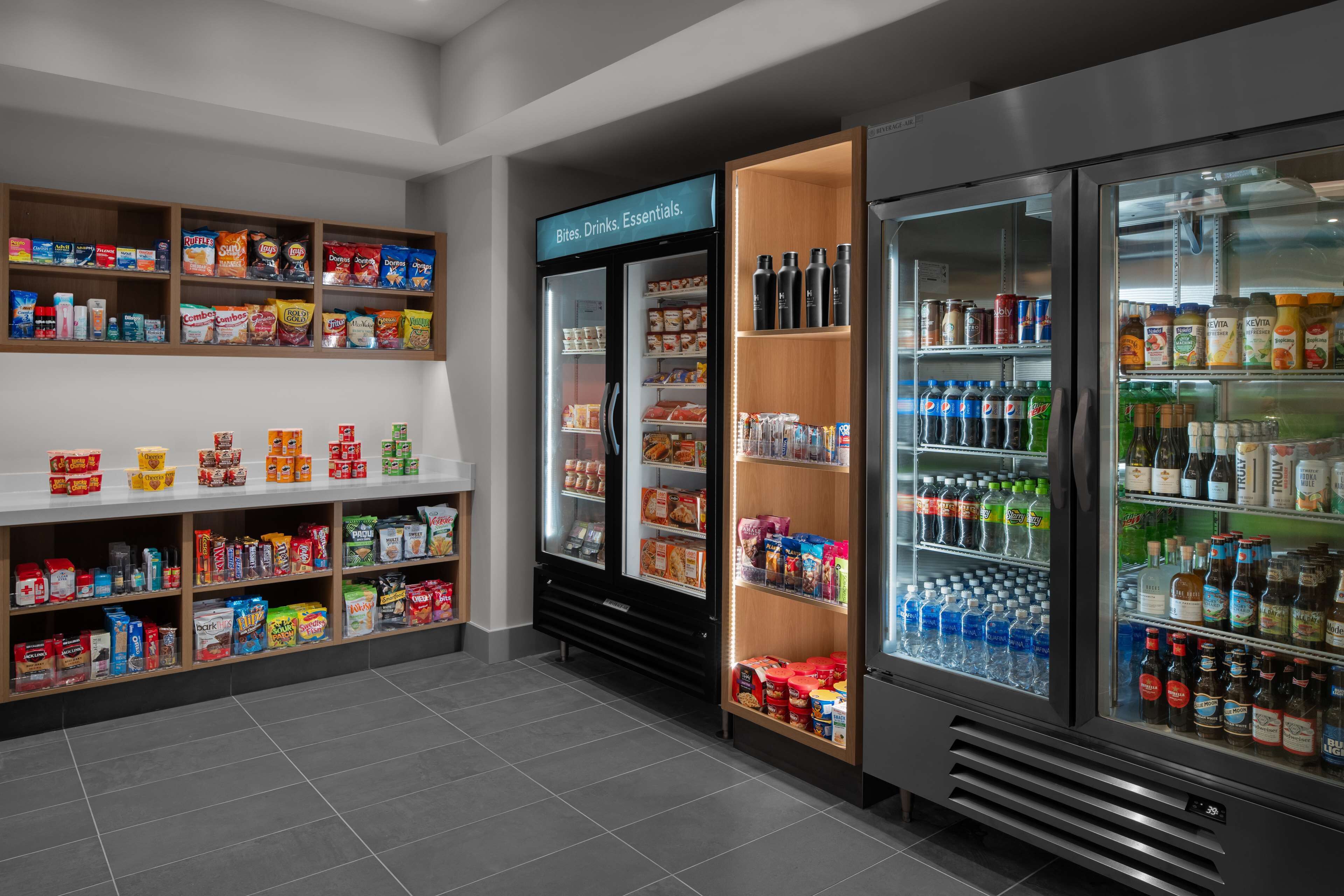 Ein Selbstbedienungskiosk für Getränke und Snacks mit gekühlten und ungekühlten Bereichen, Regalen voller verschiedener Snacks und Getränke sowie einer deutlichen Kennzeichnung des Kiosks.