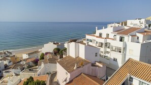 Un quartier résidentiel en bord de mer, avec des bâtiments blancs, une plage et une vue dégagée sur la mer.