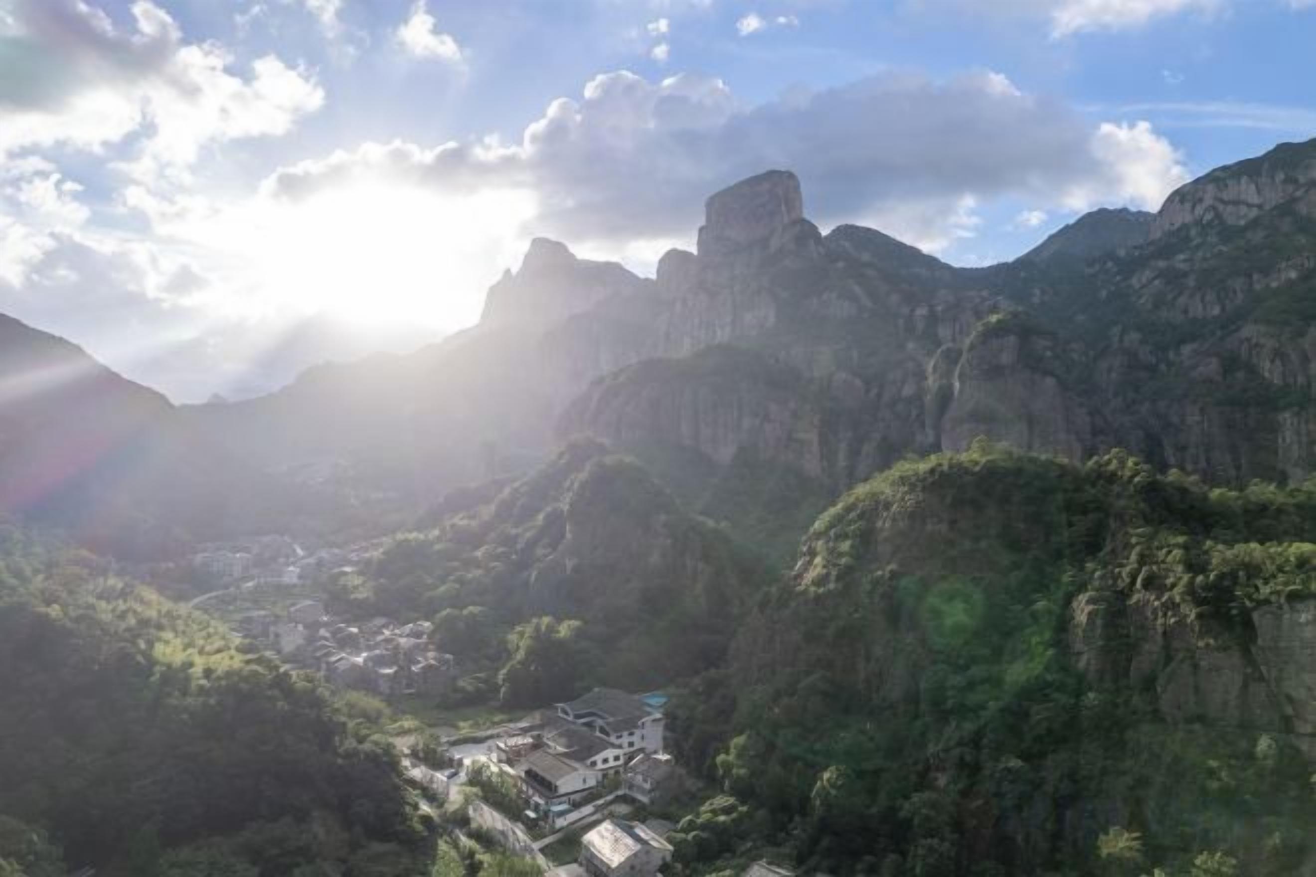 Un paysage montagneux avec une vallée et un petit village.