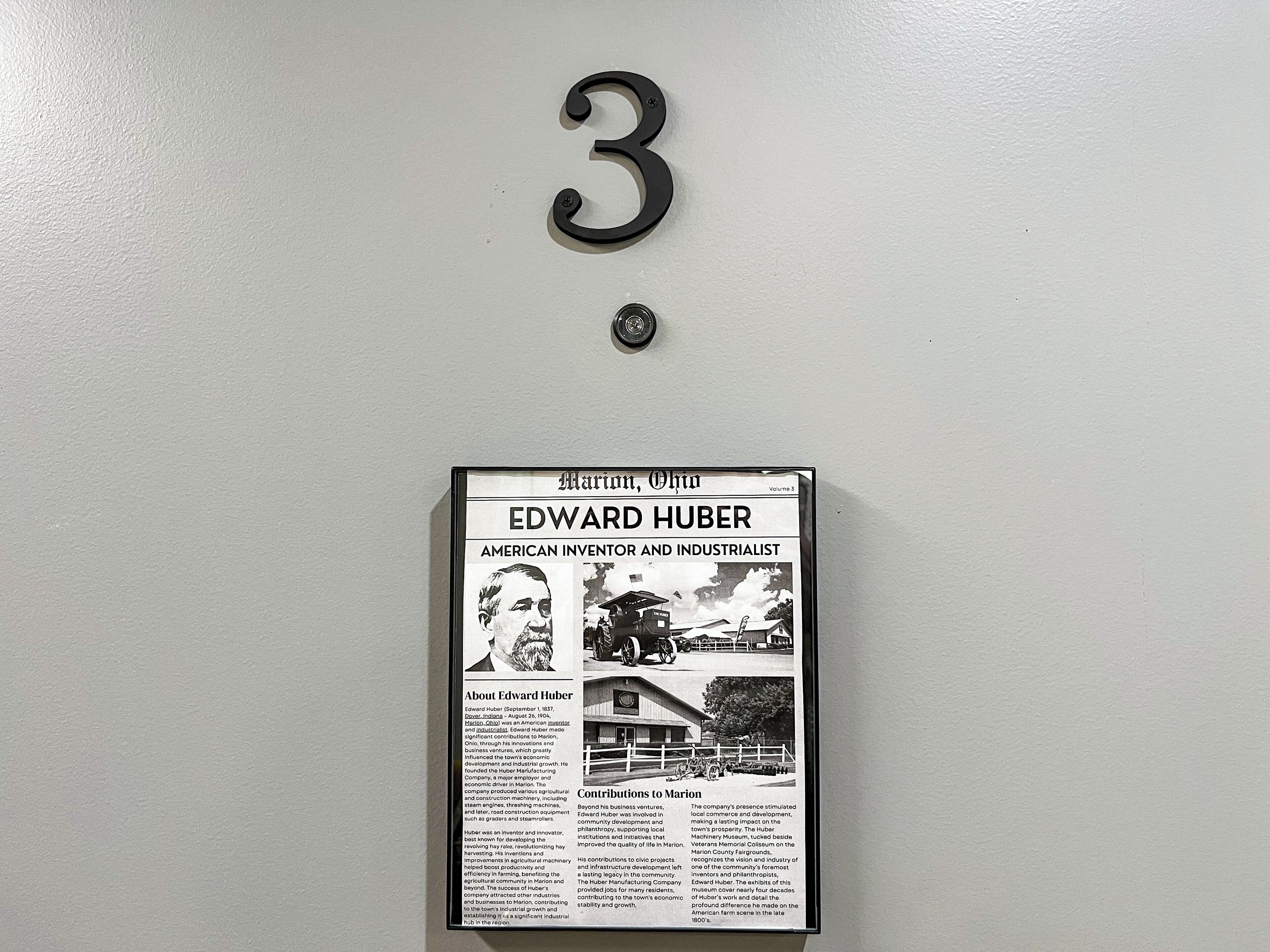 Un artículo de periódico enmarcado con el título 'Edward Huber' en una pared.