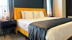 Habitació d'hotel amb un llit, vetustats i una finestra amb cortines.