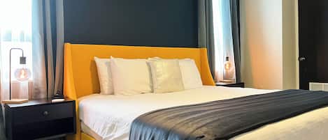 A hotel room with a bed, nightstands, and a window with curtains.