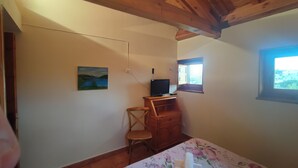 A bedroom with a bed, a wooden desk, a chair, a television, and a window. - Posada Restaurante de Serrada (Puentes Viejas)