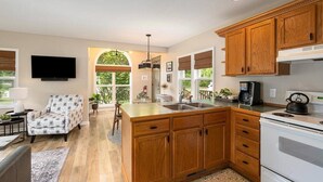 Une cuisine moderne avec des meubles en bois, un grand îlot central et une cuisinière intégrée.