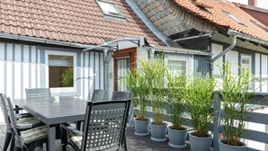 A balcony with a table and chairs, potted plants, and a view of neighboring buildings. - Holiday home in the middle of the old town of Goslar for up to 6 people (Goslar)