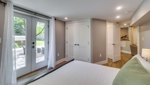 A bedroom with a large bed, a wardrobe, and a door leading to a patio. - Charming Retreat in Charlottesville w/ Deck! (Charlottesville)