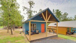 Een laag, enkelvoudig gebouw met een houten terras en zitgedeelte buiten.