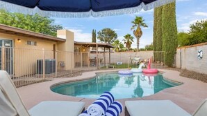 A swimming pool with lounge chairs and a covered area. - Pool Fire Pit  Ping-Pong (Tucson)