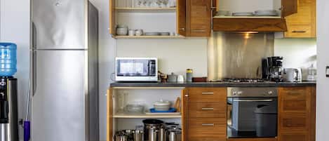 A modern kitchen with stainless steel appliances, wooden cabinets, and a built-in microwave.